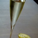 Fleur et Sekt im Glas mit Zitrone