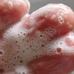 Hand mit Schaum von Bio-Haarshampoo